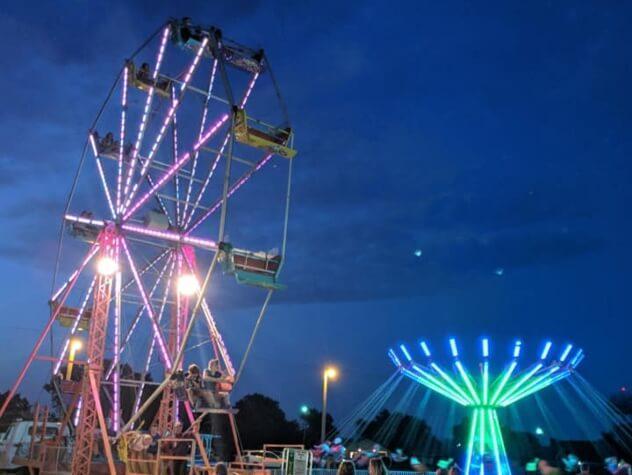 Ferris wheel and swings lit up against the night sky