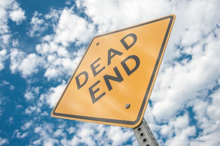 Yellow "Dead End" sign against a blue sky with clouds